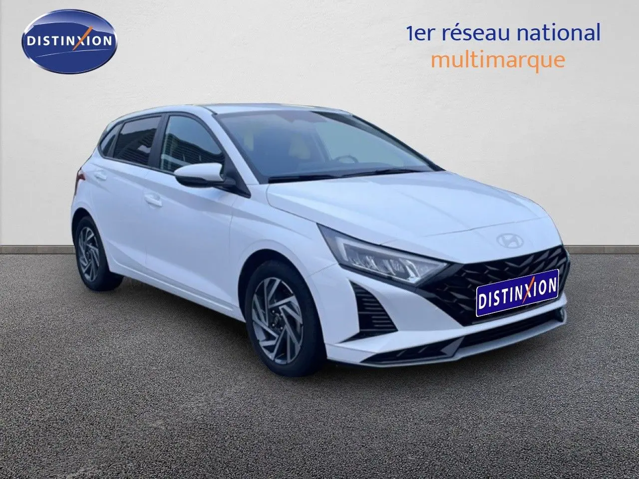 Vue 3/4 avant d’une Hyundai i20 blanche Atlas 2025 avec calandre noire et jantes alliage distinctives.