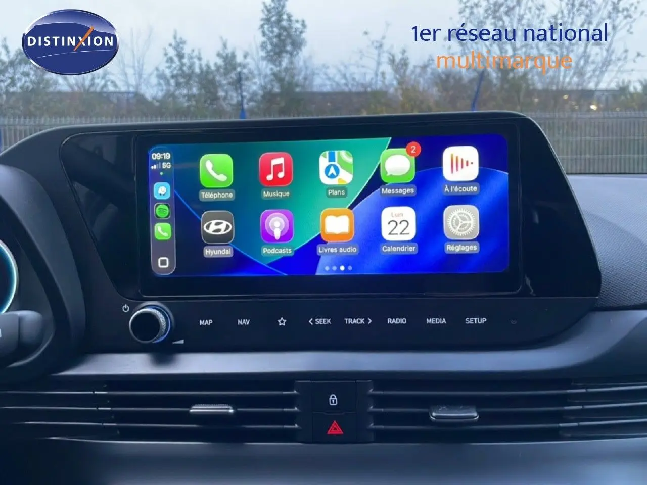 Vue rapprochée de l’écran tactile central de la Hyundai i20 blanche, affichant les applications connectées.