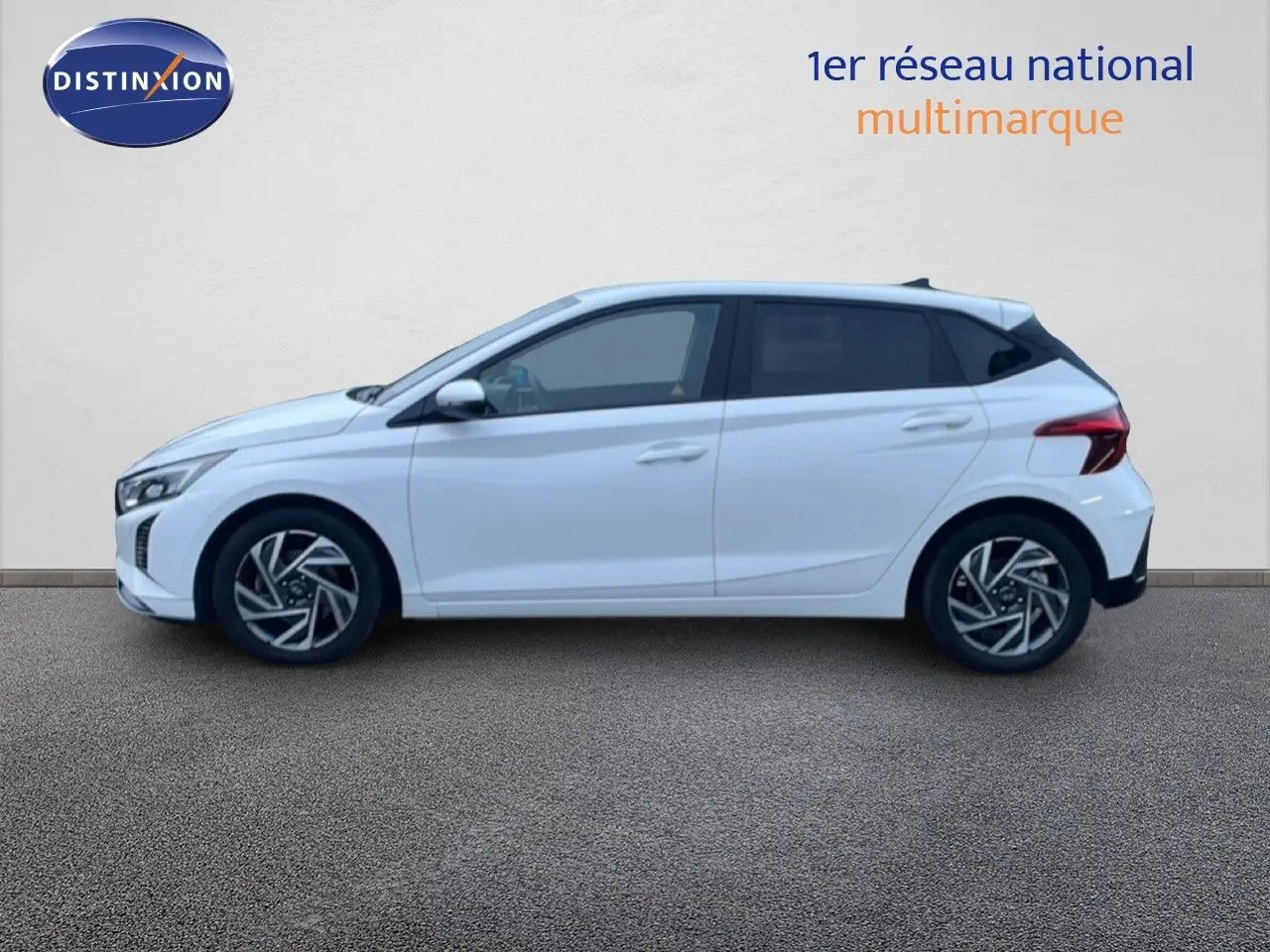 Vue de profil côté gauche d'une Hyundai i20 blanche Atlas 2025 avec jantes alliage et feux arrière LED.