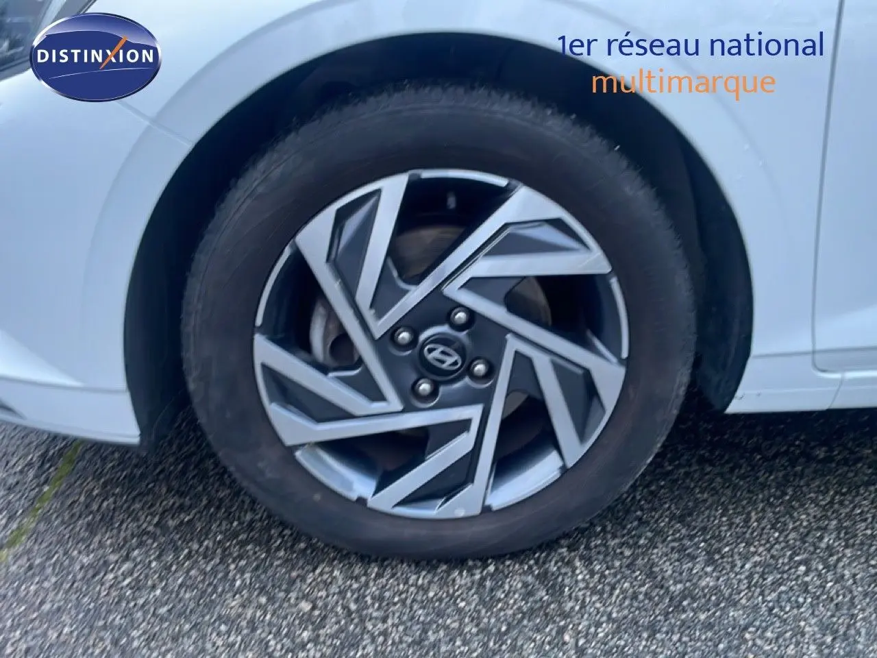 Gros plan sur la roue avant droite d'une Hyundai i20 blanche Atlas, mettant en valeur la jante au design géométrique.