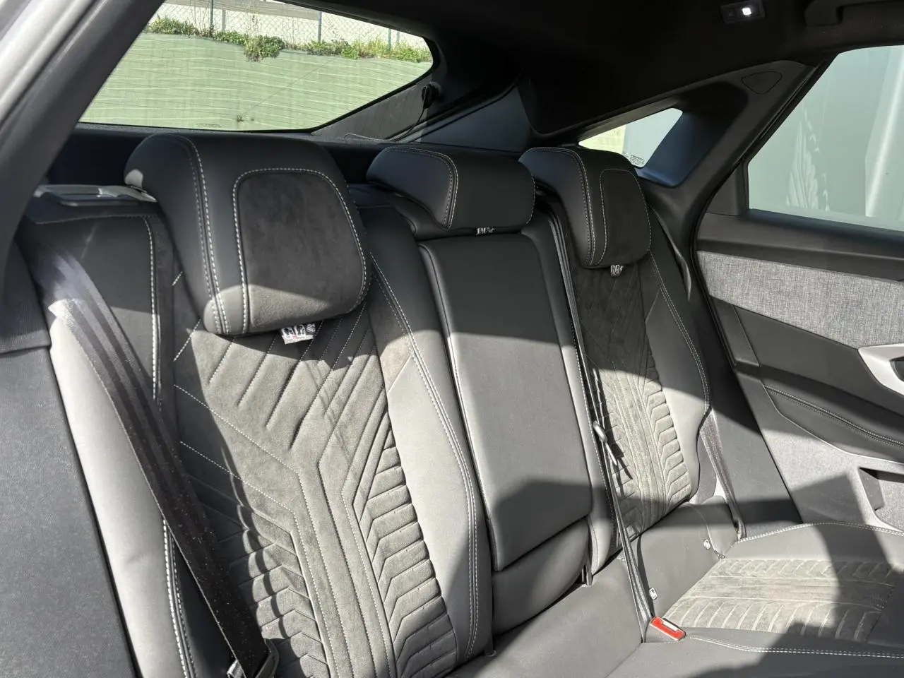 Vue intérieure des sièges arrière en Alcantara noir avec surpiqûres blanches du Peugeot 3008 Hybrid 2025.