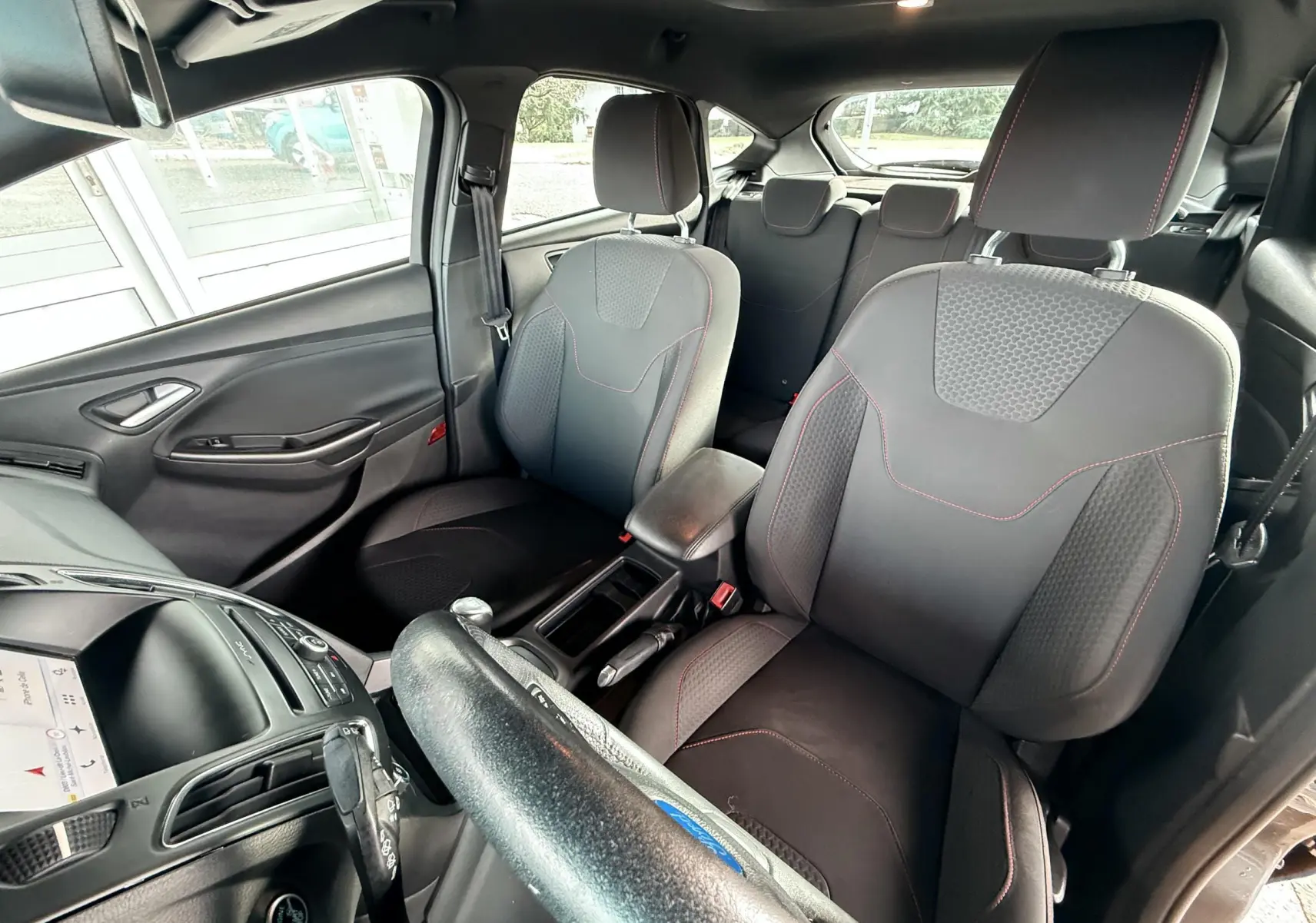 Vue rapprochée de l’écran central de navigation du tableau de bord d’une Ford Focus gris 2018, affichant un itinéraire.