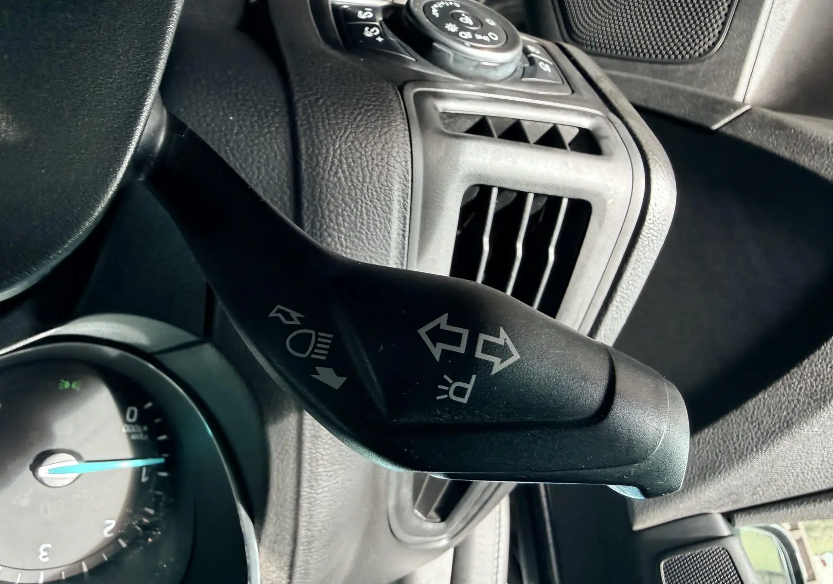 Vue intérieure côté conducteur de la Ford Focus 1.5 TDCI 120 ST Line 2018 avec sièges tissu noir et surpiqûres rouges.