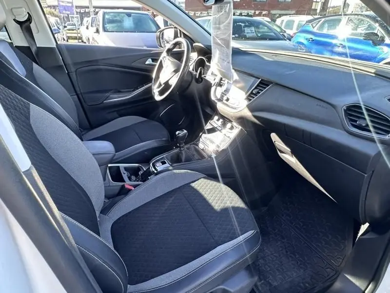 Intérieur de l’Opel Grandland X 1.6 D 120 Innovation 2018 en blanc, vue côté conducteur montrant sièges et tableau de bord.