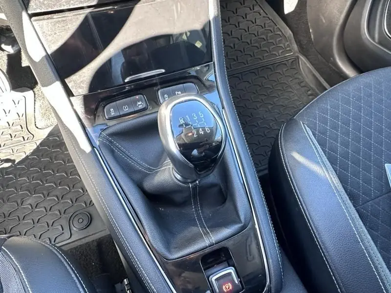 Gros plan sur la console centrale de l’Opel Grandland X 2018, montrant le levier de vitesse manuel et les sièges noirs.