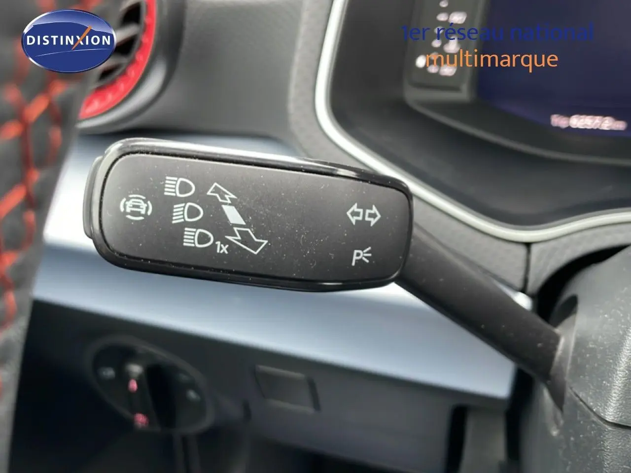 Gros plan sur la manette de clignotant à gauche dans l’habitacle d’un SEAT Arona bleu saphir métal avec toit blanc.