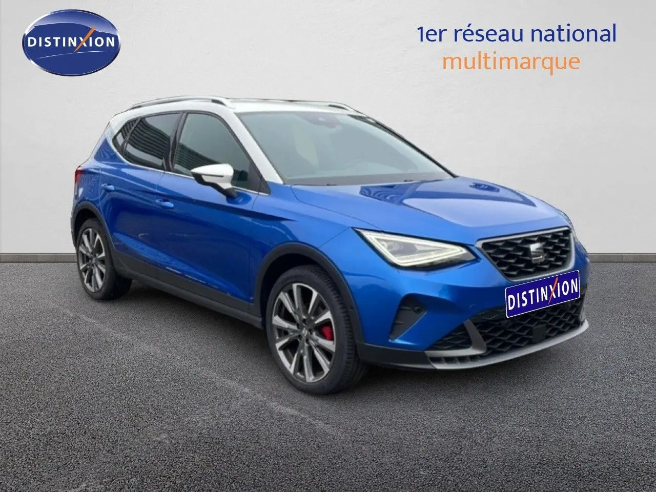 SEAT Arona 2025 bleu saphir métal avec toit blanc, vue 3/4 avant mettant en valeur les jantes alliage et les étriers rouges.