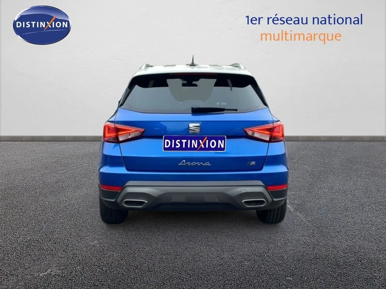 Vue arrière d'un SEAT Arona bleu saphir métal avec toit blanc, affichant ses feux et double sortie d'échappement.