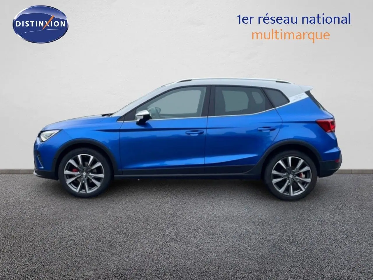 Vue de profil côté gauche d’un SEAT Arona 2025 bleu saphir métal avec toit blanc et jantes alliage.