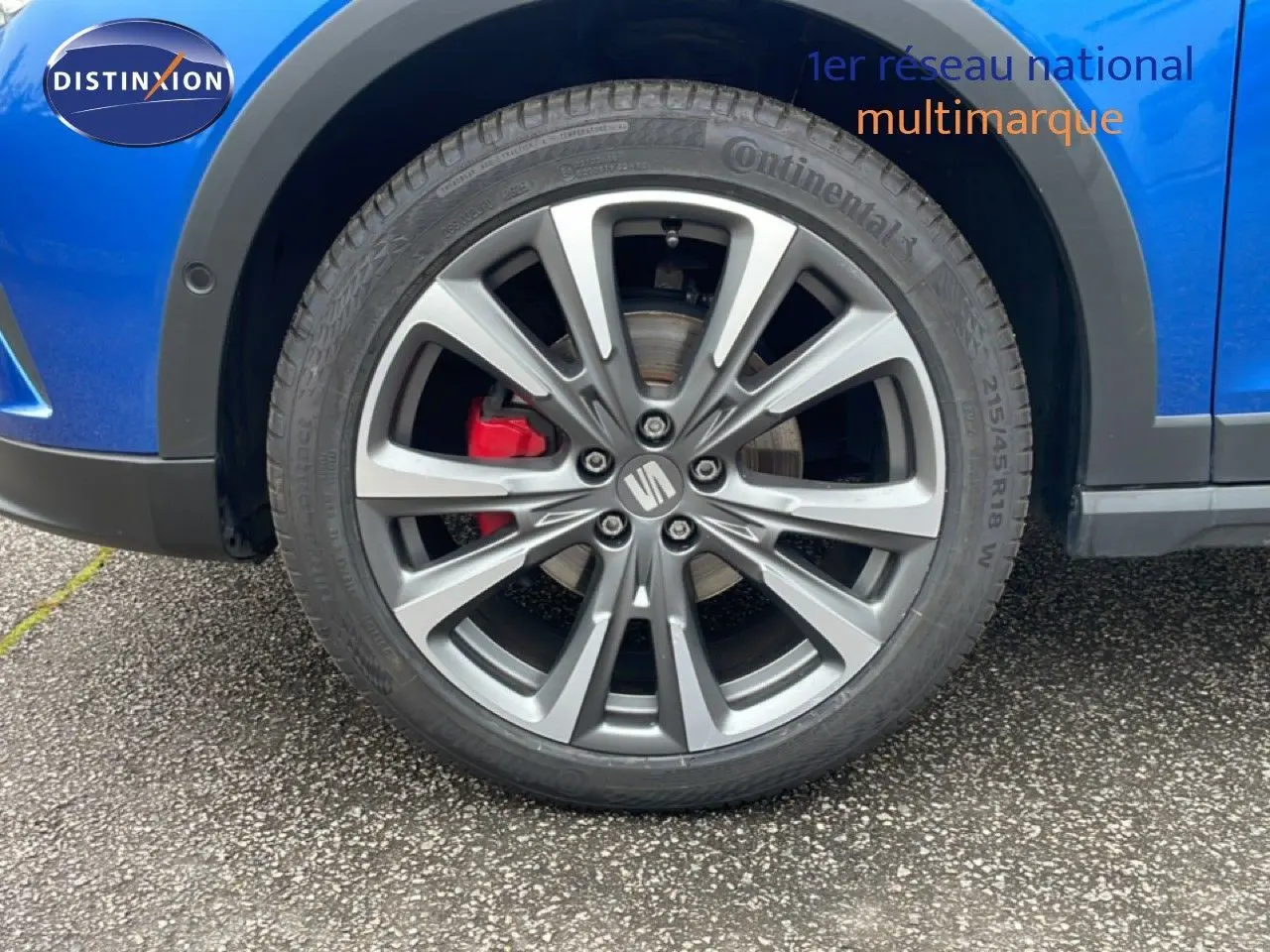 Gros plan sur la roue avant droite d'une SEAT Arona bleu saphir avec étrier de frein rouge et jante alliage.