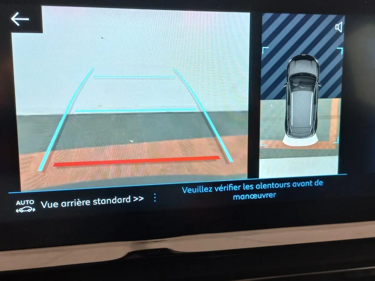 Affichage écran de caméra de recul et vue aérienne du Peugeot 3008 noir en mode assistance au stationnement arrière.