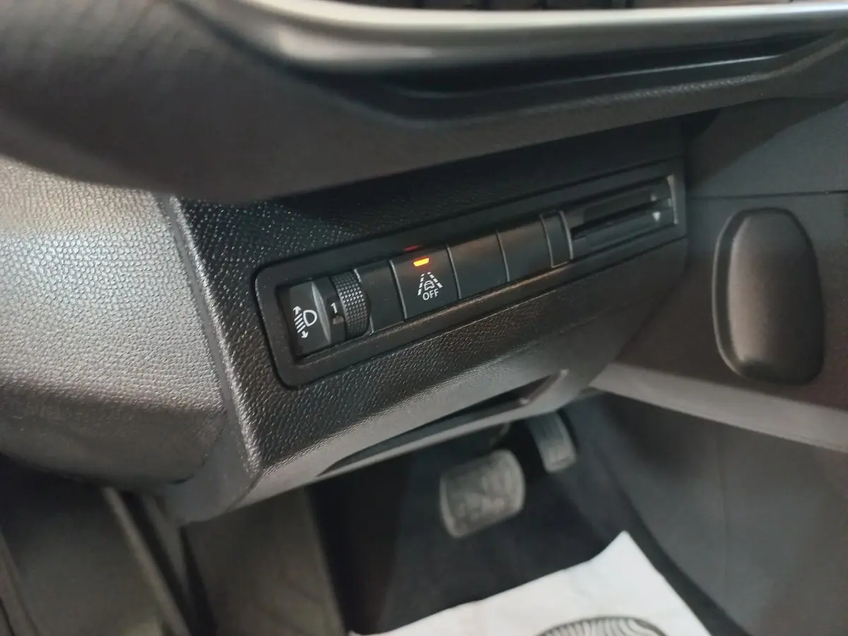 Détail intérieur côté gauche du tableau de bord noir du Peugeot 3008 2022 avec commandes d’éclairage et assistance à la conduite.