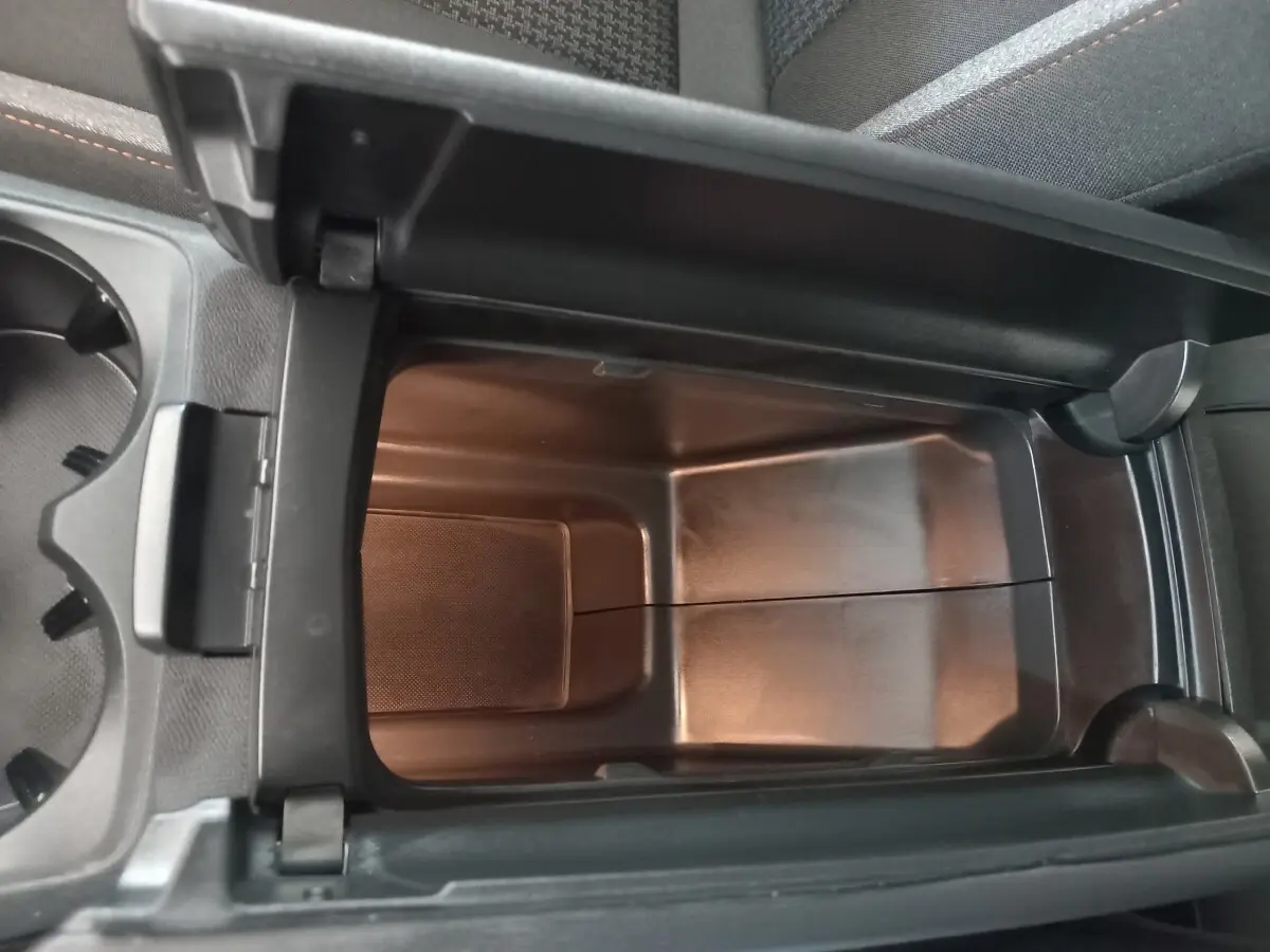 Vue plongeante sur le rangement réfrigéré noir dans l'accoudoir central du Peugeot 3008 2022 PureTech.