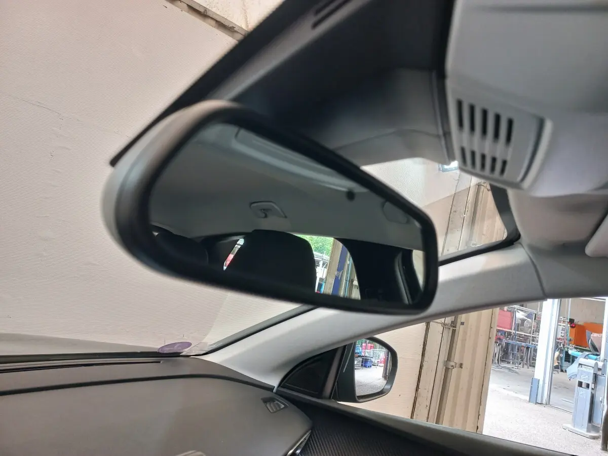 Vue intérieure du rétroviseur central d'un Peugeot 3008 noir 2022, avec partie du tableau de bord et vitre côté droit visibles.