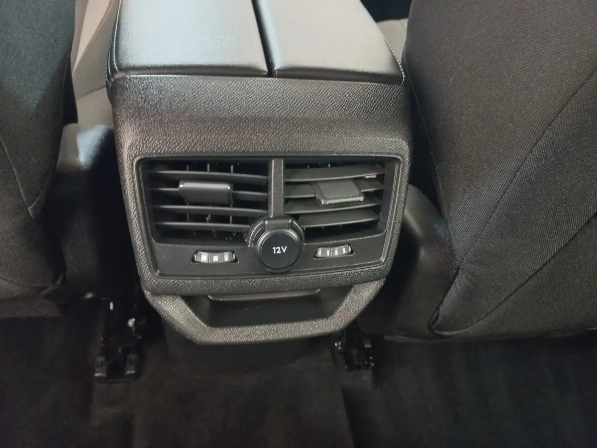 Vue rapprochée de la console arrière noire avec sorties d'air et prise 12V du Peugeot 3008 2022.