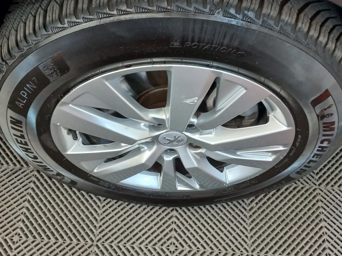 Gros plan sur la jante alliage argentée et le pneu Michelin d’un Peugeot 3008 noir, vue latérale.