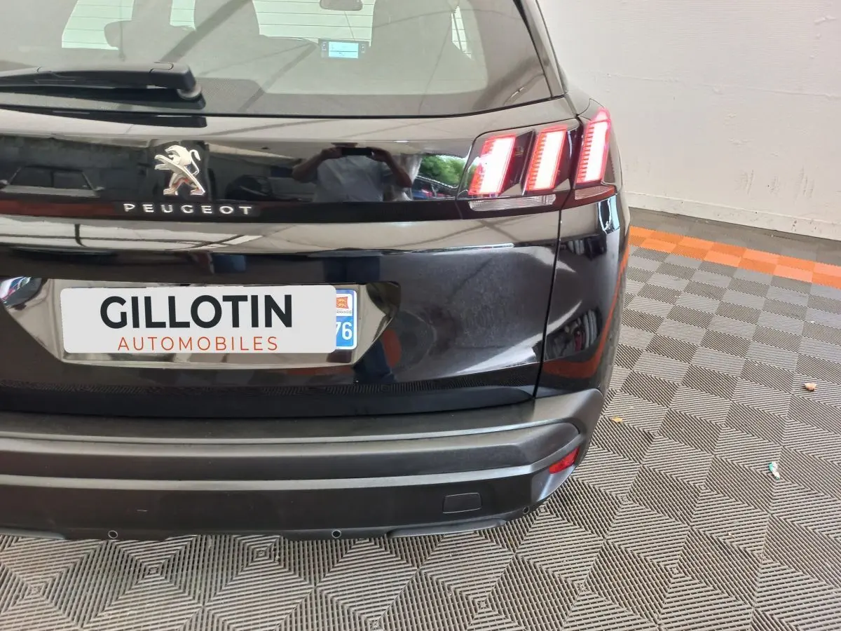 Vue arrière droite du Peugeot 3008 noir avec feux arrière LED distinctifs et logo Peugeot visible.