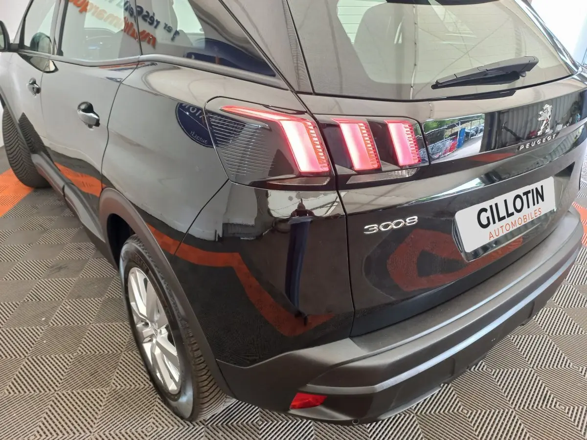 Vue 3/4 arrière droite du Peugeot 3008 noir avec feux arrière LED distinctifs et logo Peugeot visible.