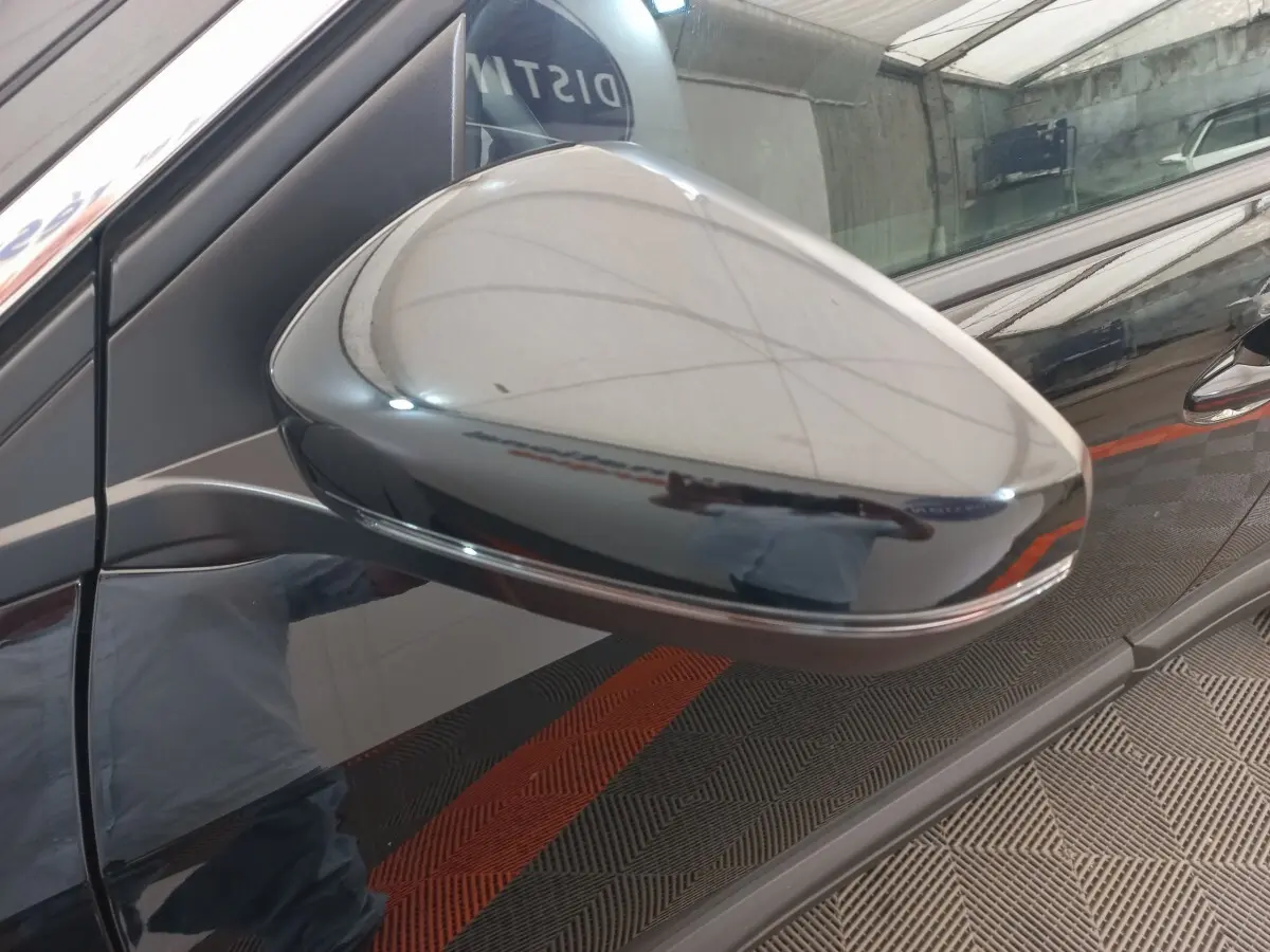 Rétroviseur côté gauche noir brillant du Peugeot 3008 2022, reflet net sur la carrosserie noire du véhicule.