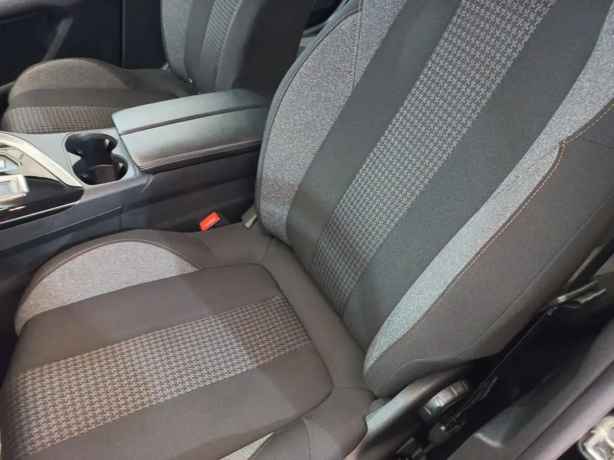 Gros plan sur le siège avant droit tissu gris et noir du Peugeot 3008 2022 avec accoudoir central et console noire.