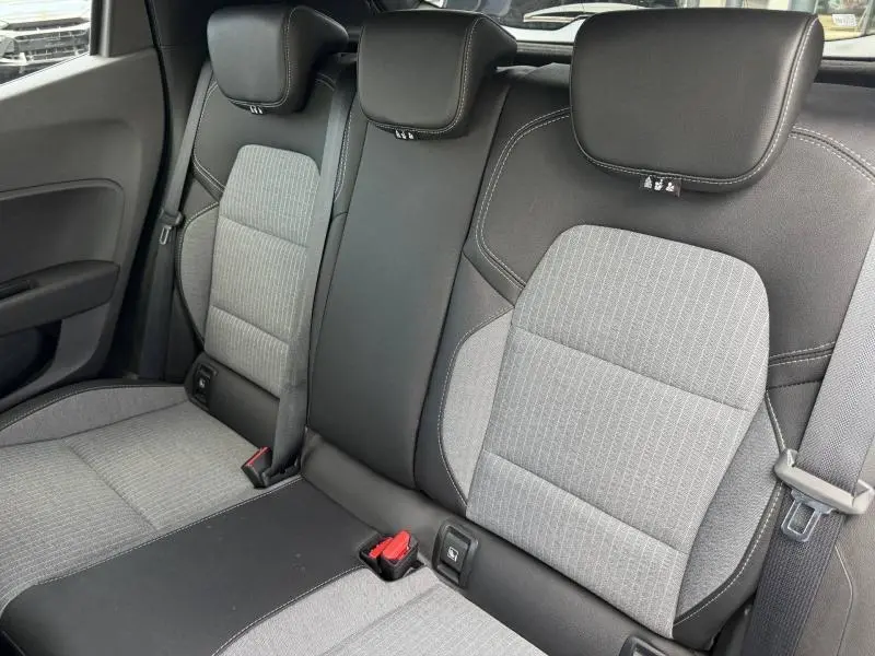 Vue rapprochée de la banquette arrière gris clair et noir de la Renault Clio 2025 avec ceintures et appuie-têtes intégrés.