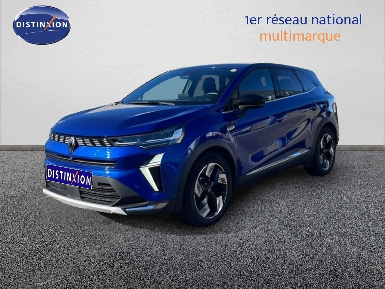 Renault Symbioz bleu Iron Metal en 3/4 avant droit, SUV hybride avec calandre lumineuse et jantes modernes.