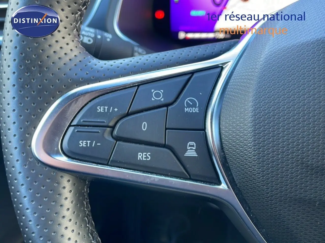 Gros plan sur les commandes au volant en cuir perforé noir du Renault Symbioz 2025, version hybride bleu iron metal.