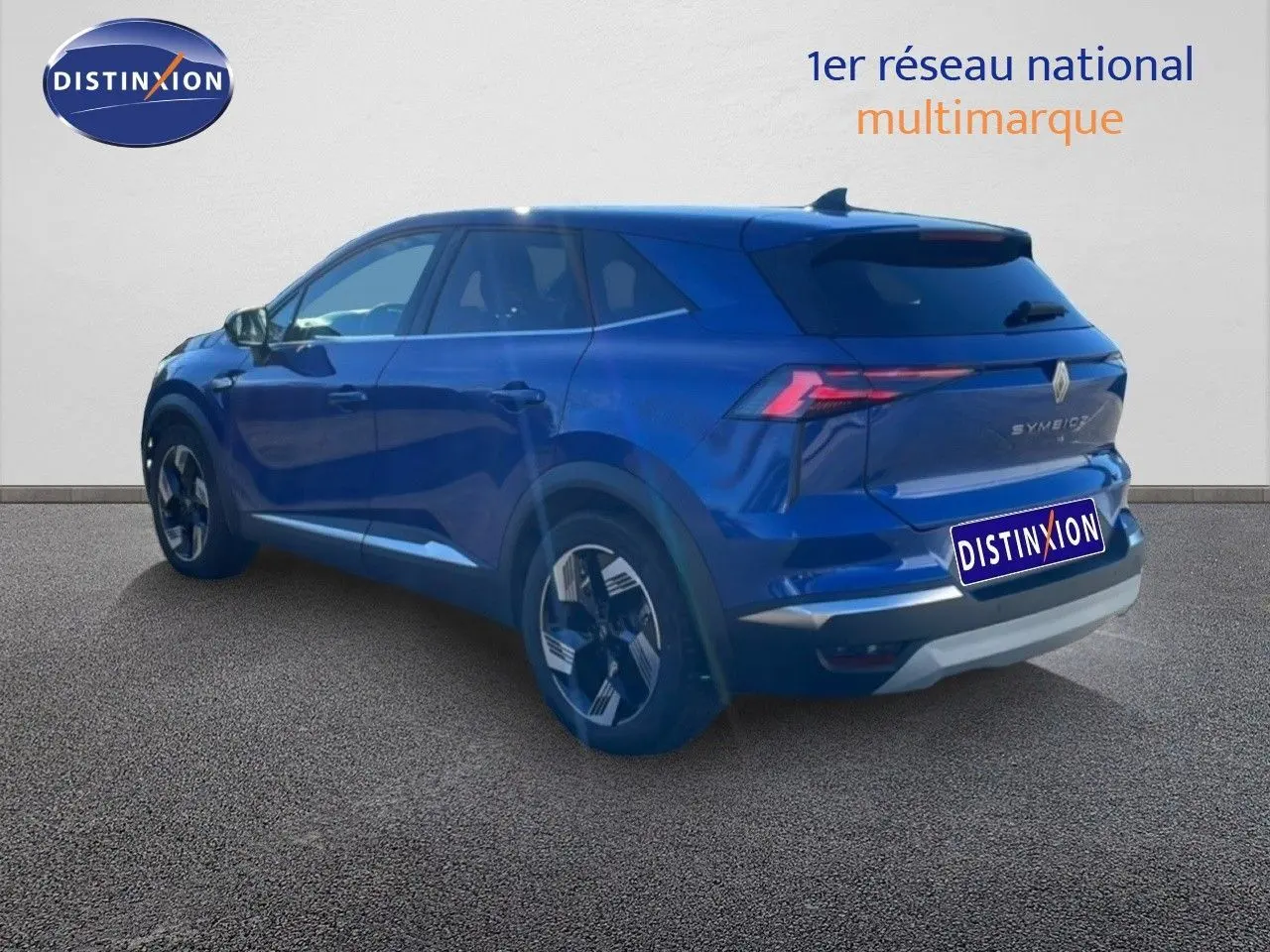 Vue 3/4 arrière droite d’un Renault Symbioz bleu iron metal, SUV hybride avec feux arrière LED distinctifs.