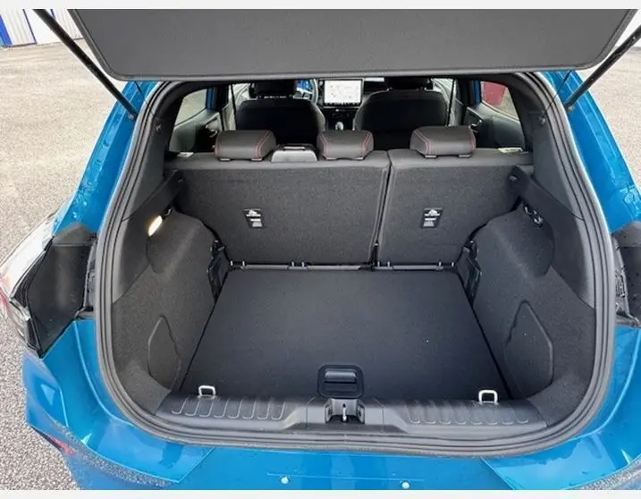 Coffre ouvert vu de l'arrière d'un Ford Puma 2025 bleu Aqua Blue, montrant l'espace de chargement et les sièges arrière.