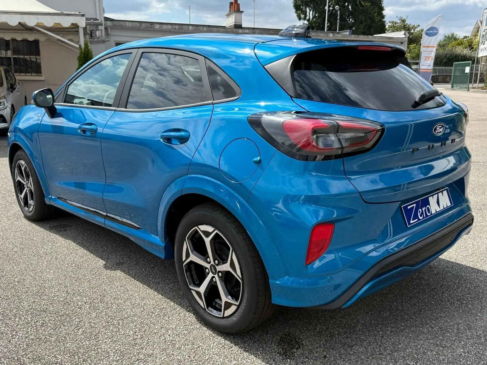Ford Puma 2025 bleu Aqua Blue en vue 3/4 arrière droit, avec jantes alliage et vitres teintées.