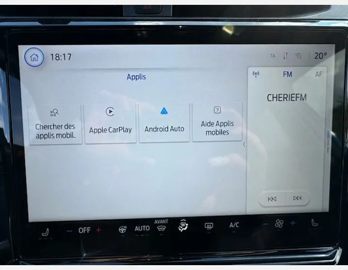 Écran tactile central du Ford Puma 2025 affichant les applications Apple CarPlay, Android Auto et la radio FM sur fond clair.