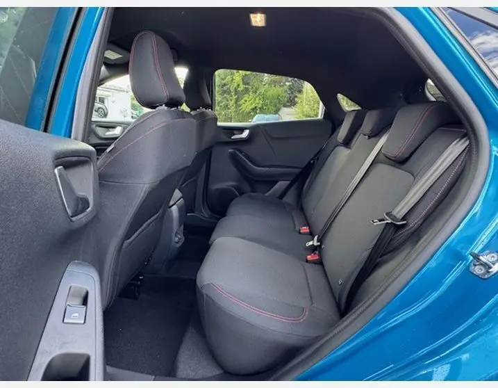 Vue intérieure arrière côté droit du Ford Puma bleu Aqua Blue 2025, sièges sport noirs avec surpiqûres rouges ST LINE.