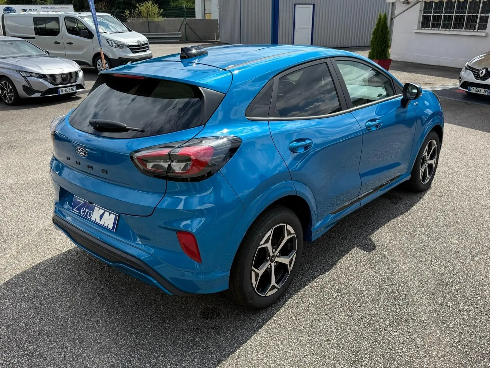 Vue 3/4 arrière droite d'une Ford Puma bleu aqua avec jantes alliage et vitres teintées sur parking.