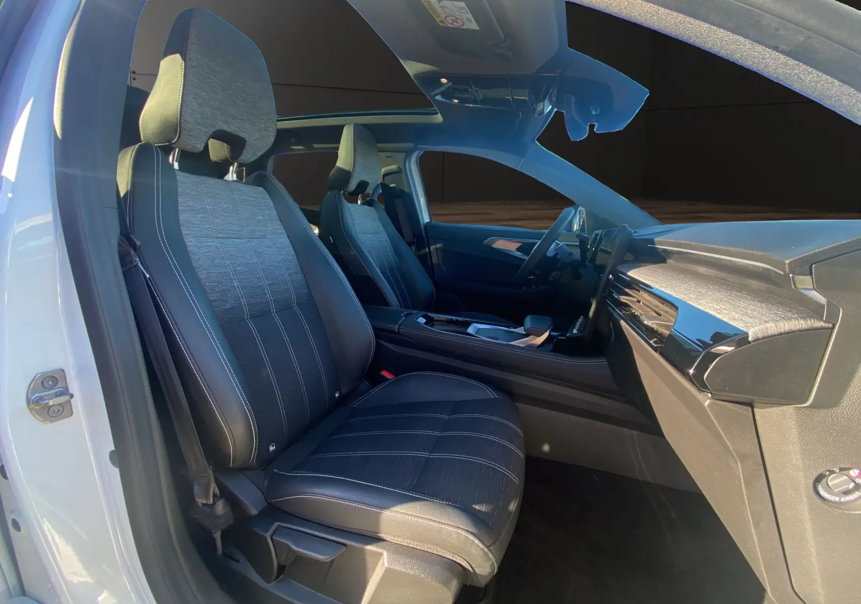 Vue intérieure côté gauche du Renault Austral Full Hybrid blanc nacré, mettant en valeur les sièges et le toit panoramique.