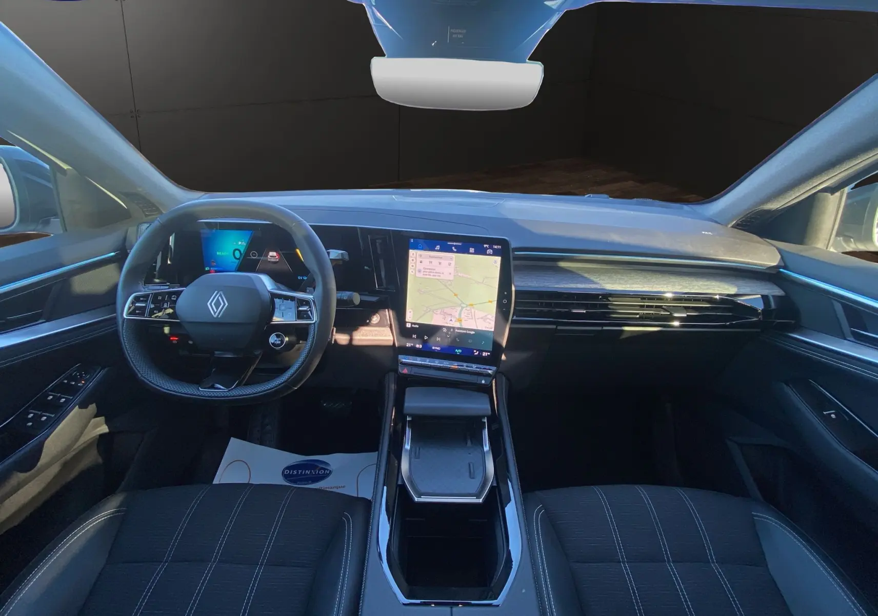 Vue intérieure avant du Renault Austral 2025, tableau de bord moderne avec écran tactile vertical et volant multifonction noir.