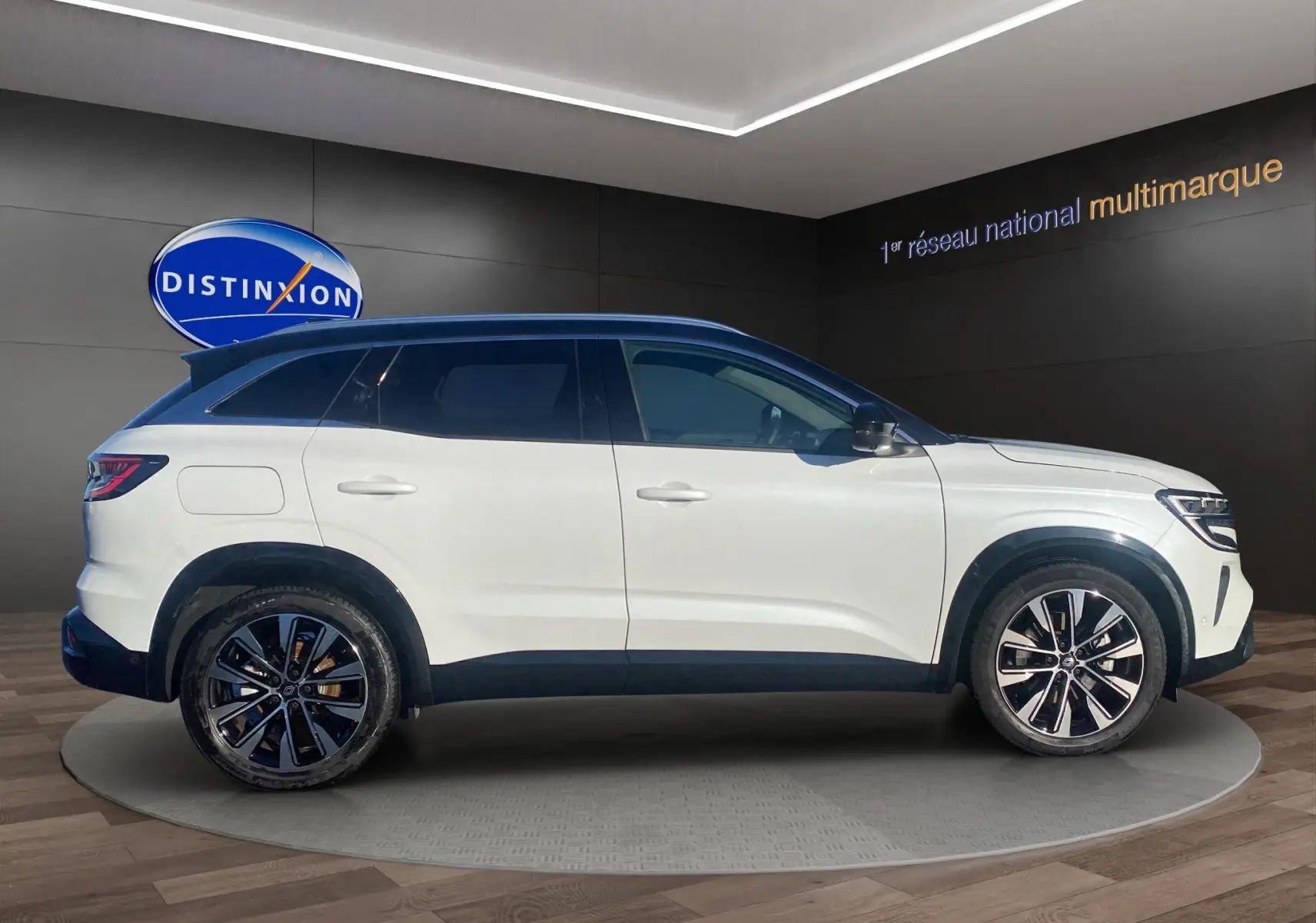 Vue de profil côté gauche d’un Renault Austral blanc nacré avec toit noir panoramique et jantes alu 19 pouces.