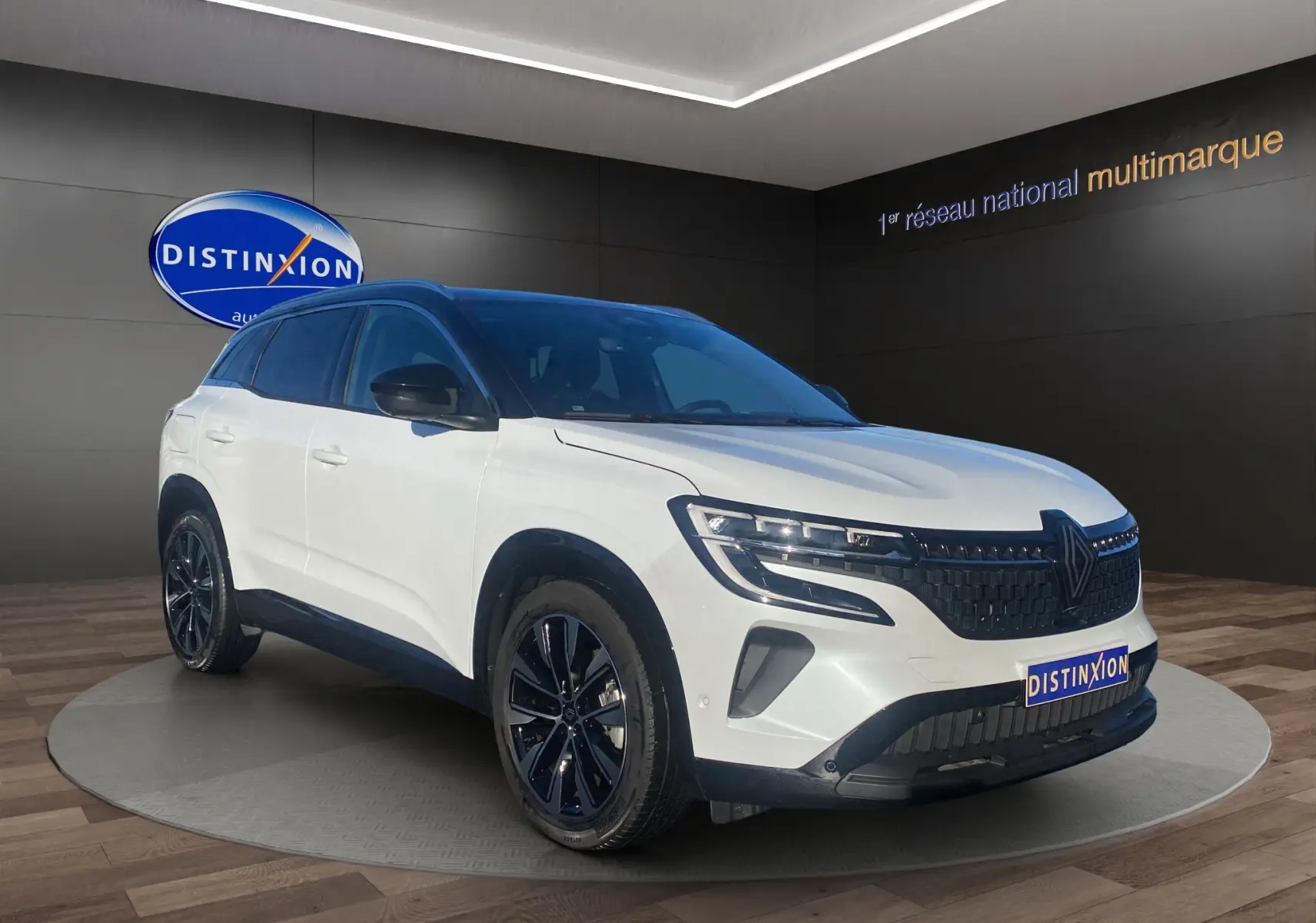 Renault Austral blanc nacré avec toit noir, vue 3/4 avant droit, jantes alu noires et calandre moderne.