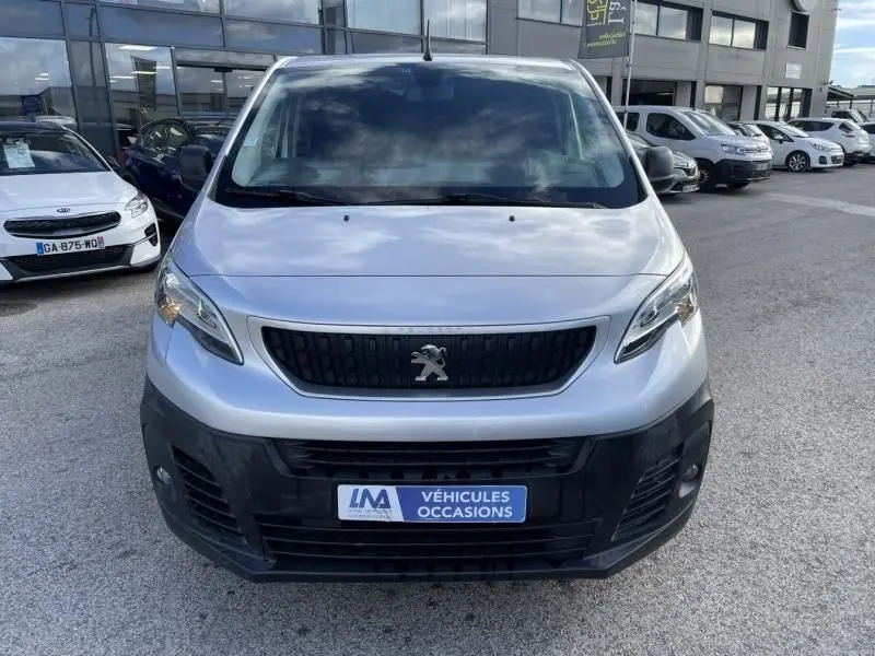 Vue de face d’un Peugeot Expert Fourgon gris métal 2018 avec calandre noire et plaque « Véhicules Occasions » visible.