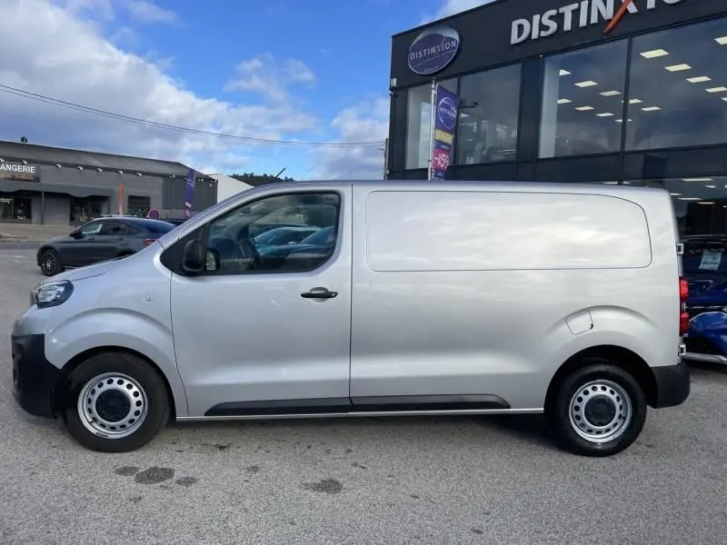 Vue de profil côté gauche d'un Peugeot Expert Fourgon gris métal 2018, avec jantes acier et carrosserie lisse.