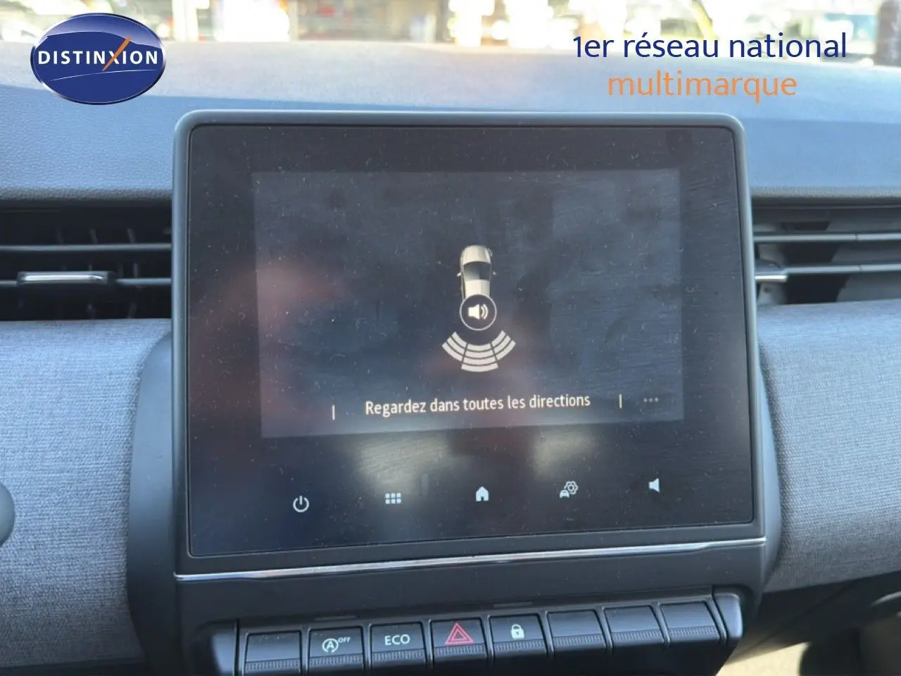 Tableau de bord de Renault Clio blanc 2025, vue centrée sur l'écran tactile affichant une alerte de sécurité.