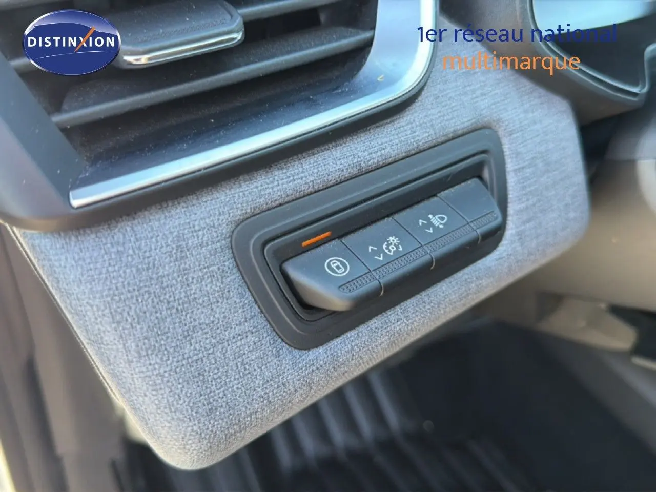 Détail des commandes d'éclairage sur tableau de bord avec finition tissu gris dans Renault Clio blanche 2025.