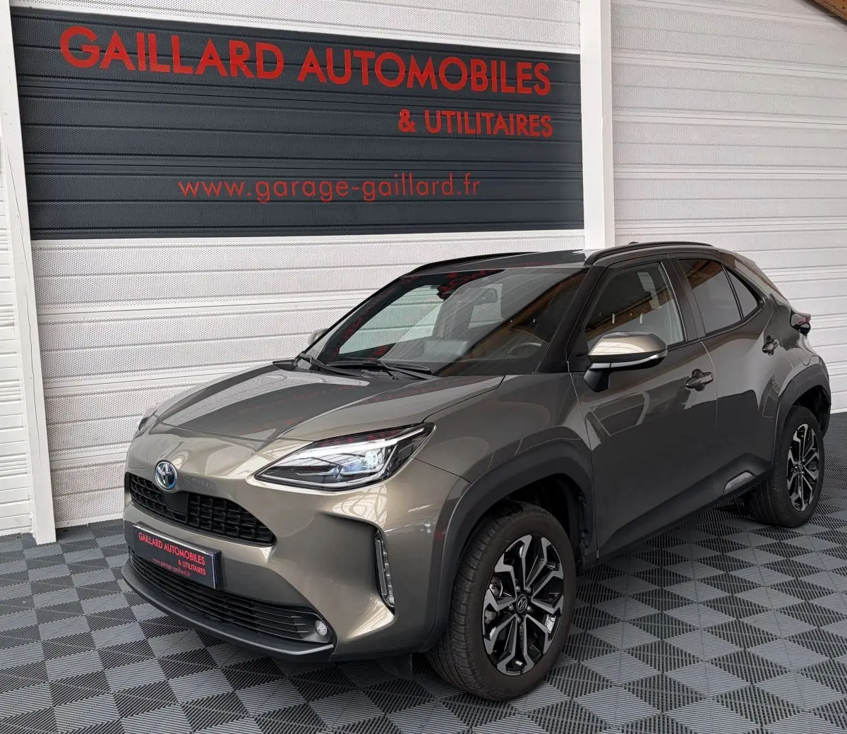 Toyota Yaris Cross gris clair vue 3/4 avant droit, avec jantes alliage et rétroviseurs argentés.
