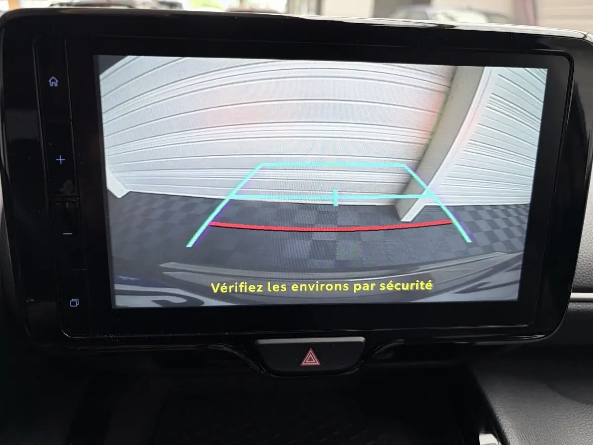 Écran tactile central montrant la caméra de recul avec guidage, à l'intérieur d'une Toyota Yaris Cross gris clair 2024.