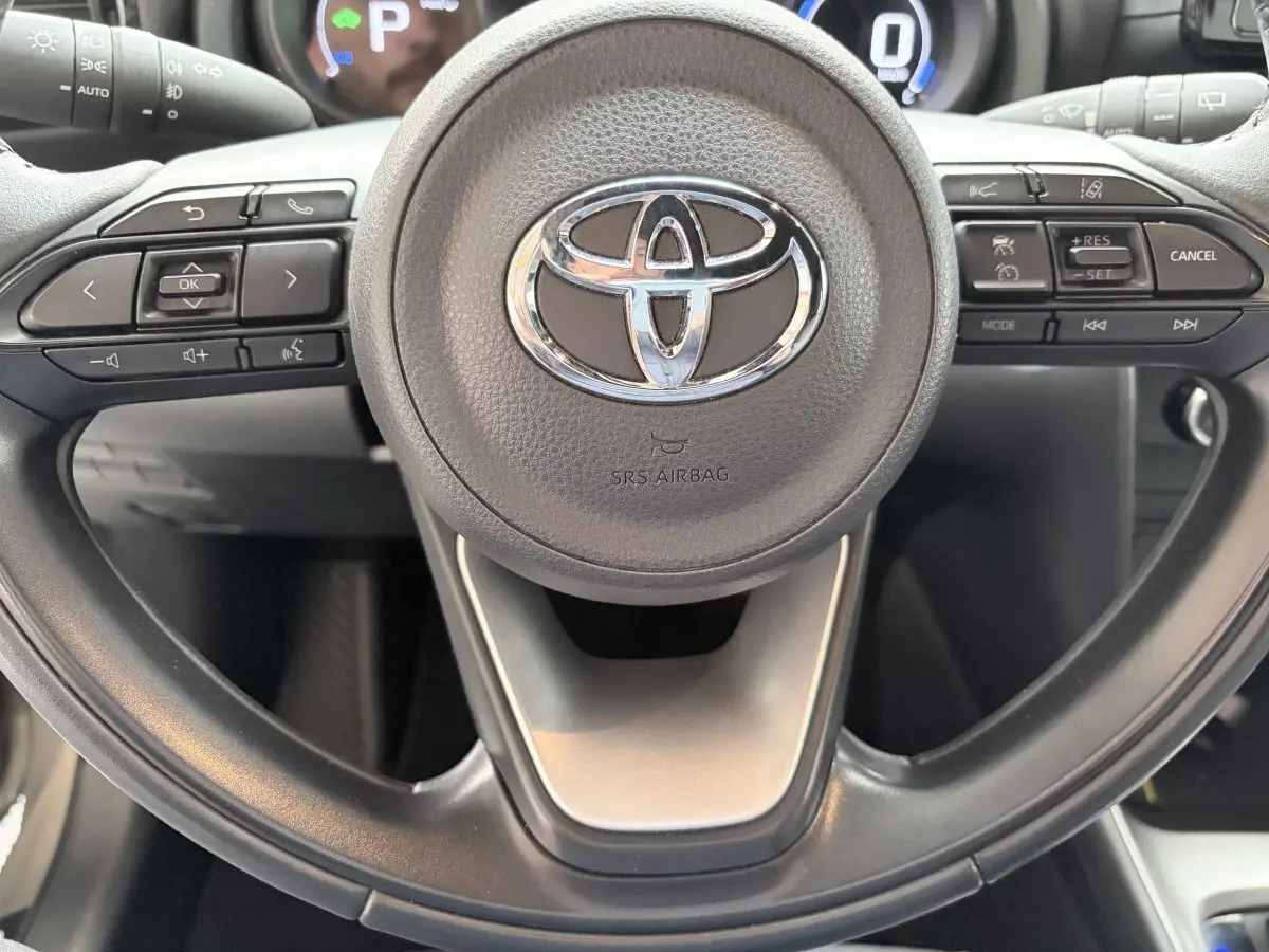 Vue rapprochée du volant cuir multifonctions gris foncé de la Toyota Yaris Cross 2024, avec commandes intégrées.