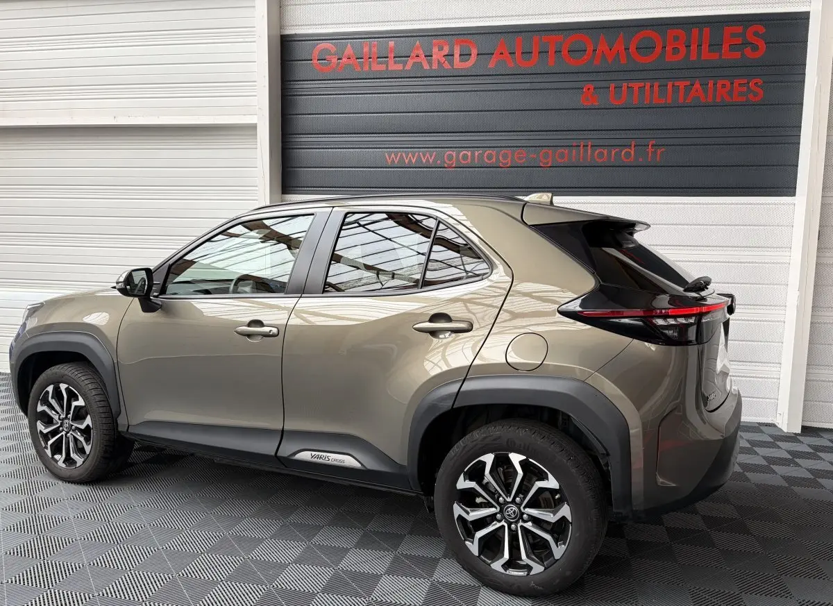 Vue latérale droite d'un Toyota Yaris Cross gris clair 2024 avec jantes alliage et détails noirs contrastants.