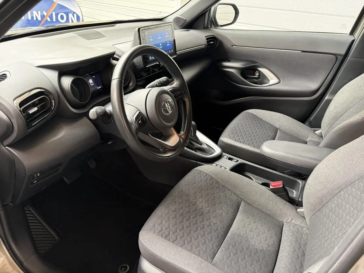 Intérieur avant droit de la Toyota Yaris Cross 1.5 Hybrid 116h avec volant cuir multifonctions et écran tactile central.