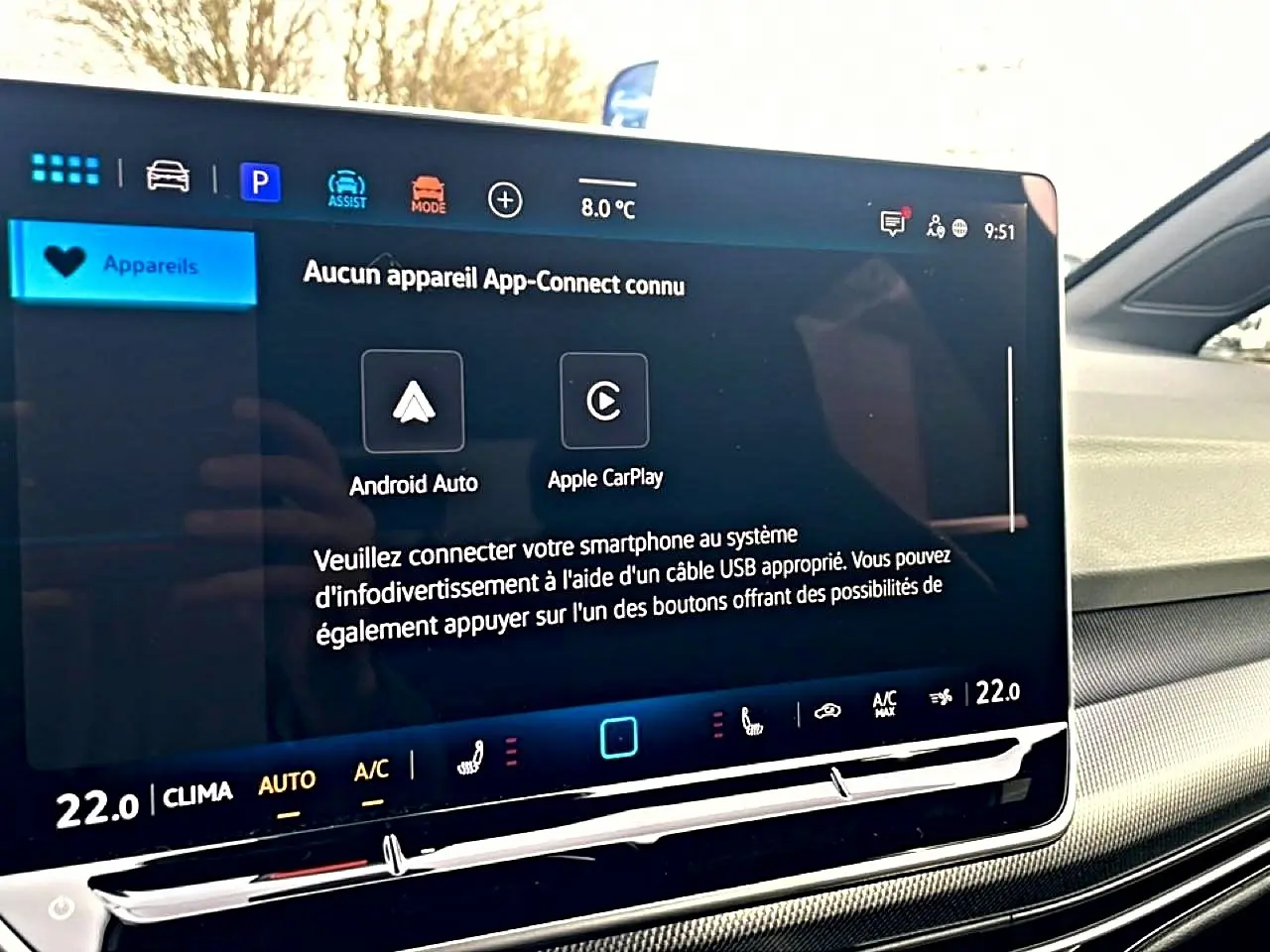 Écran tactile central affichant les options Android Auto et Apple CarPlay dans l'habitacle clair d'une Volkswagen Golf noire.