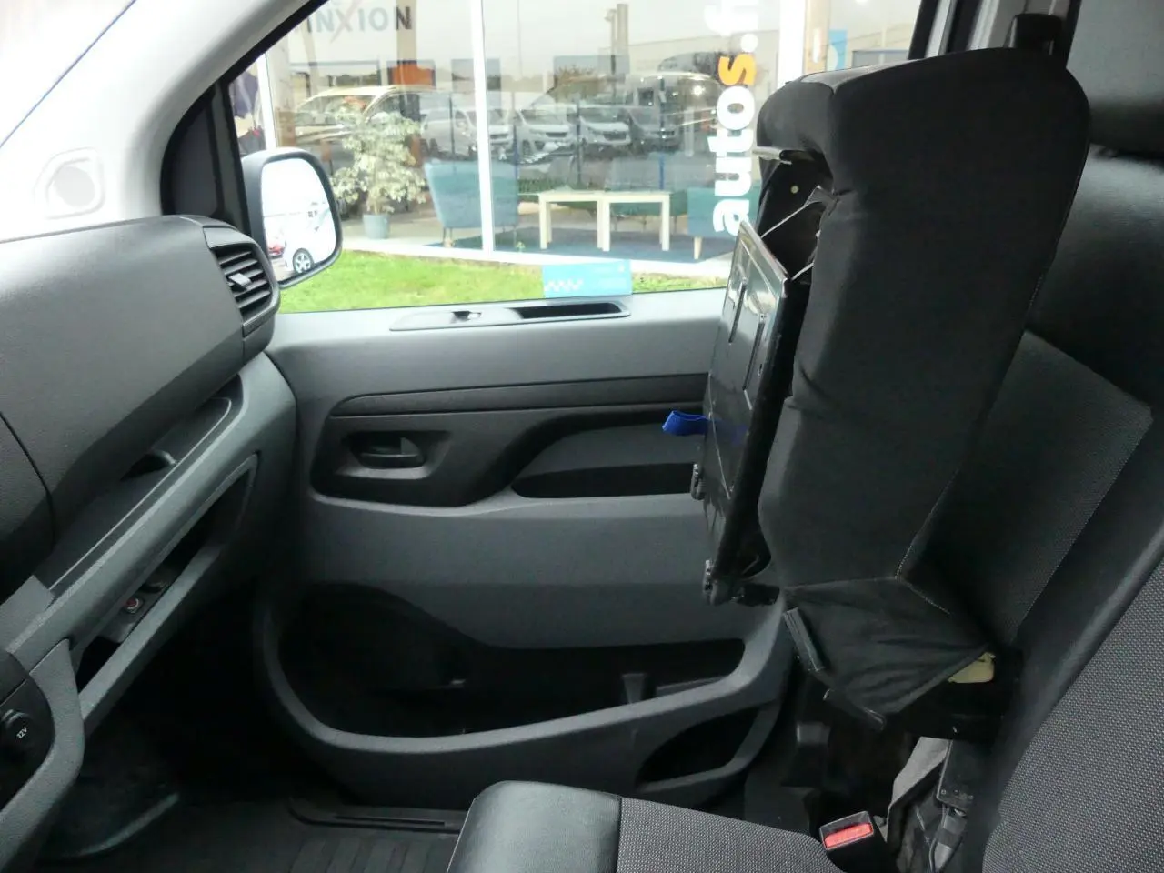 Intérieur côté passager du Peugeot Expert Fourgon blanc 2019, siège avant relevé et planche de bord grise.