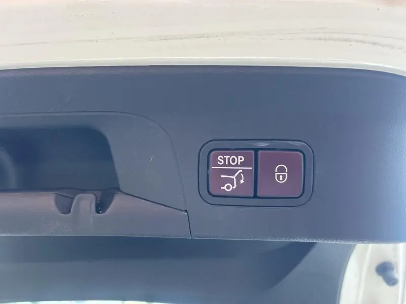 Boutons de commande du coffre électrique et de verrouillage sur le hayon intérieur d'un Mercedes GLC Coupé blanc diamant.