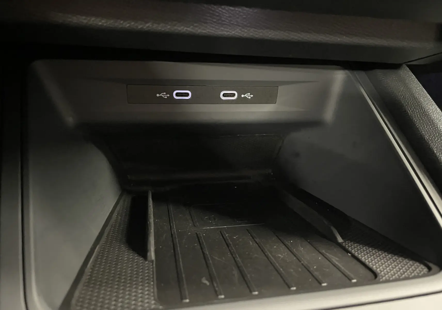 Gros plan sur la zone de rangement avec deux ports USB-C lumineux dans l'habitacle du CUPRA Formentor gris mat.